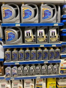 Everest and Mobil 1 full-synthetic engine oil bottles displayed together on a store shelf in Nigeria, in both 5-litre and 1-litre sizes